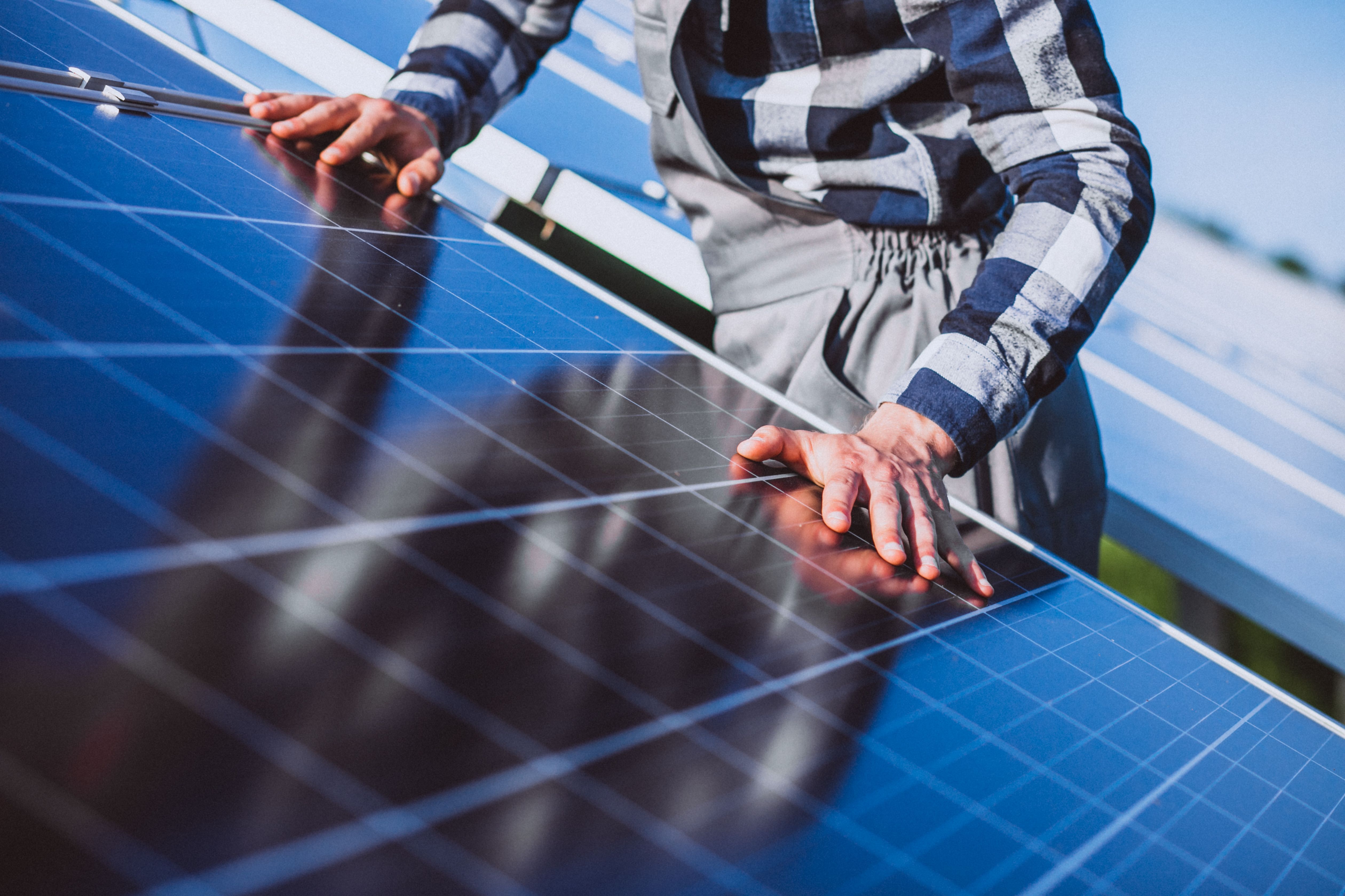 Homme installant un panneau solaire